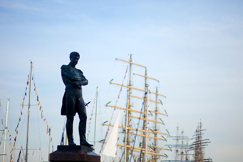 Monument to Admiral von Krusenstern in front of sailing ships moored on Vasilevskiy Island in St Petersburg, Russia